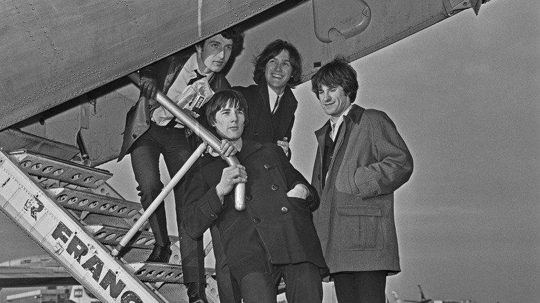 the kinks boarding a plane in london en route to perform in france, 1965