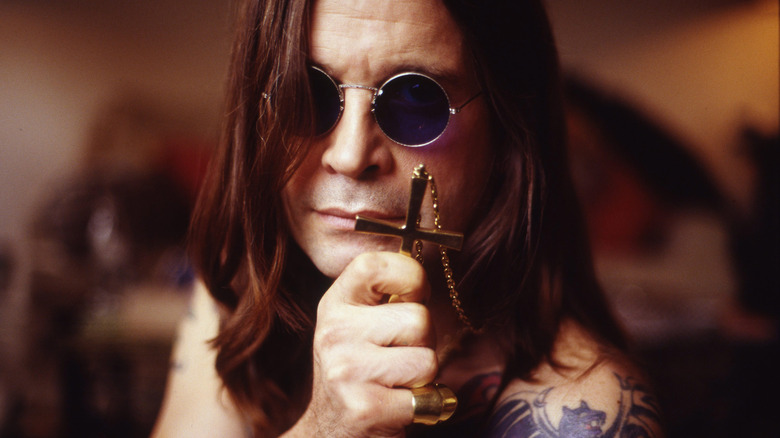 Ozzy Osbourne posing with cross pendant