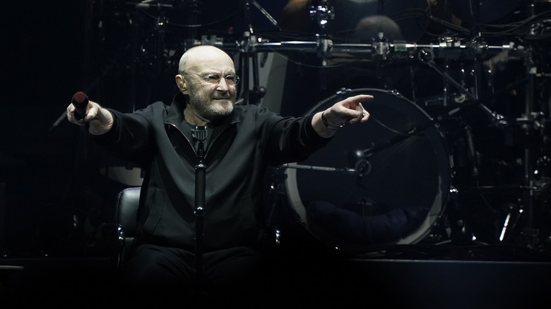 Phil Collins performs seated onstage