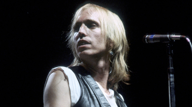 Tom Petty onstage in the '80s looking off