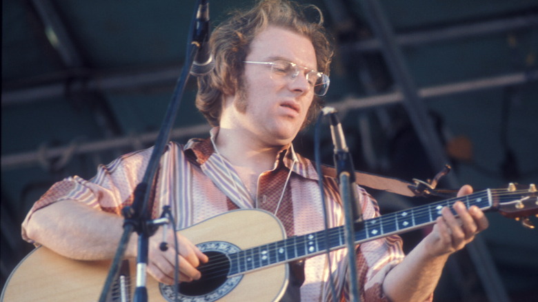 Van Morrison grimaces and plays guitar