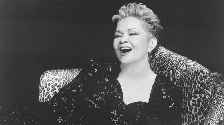 Etta James sitting on chair and smiling on stage
