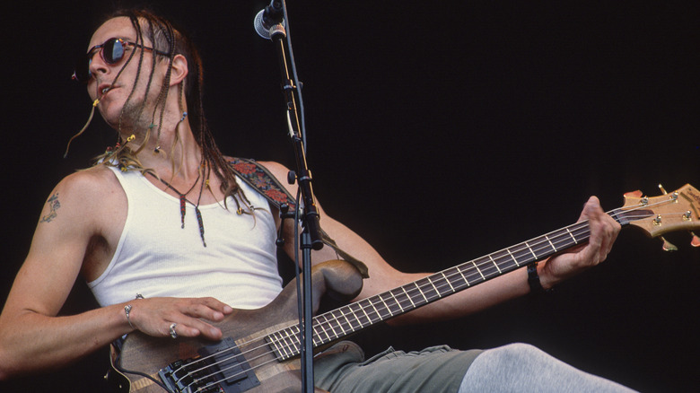 Les Claypool playing bass on stage