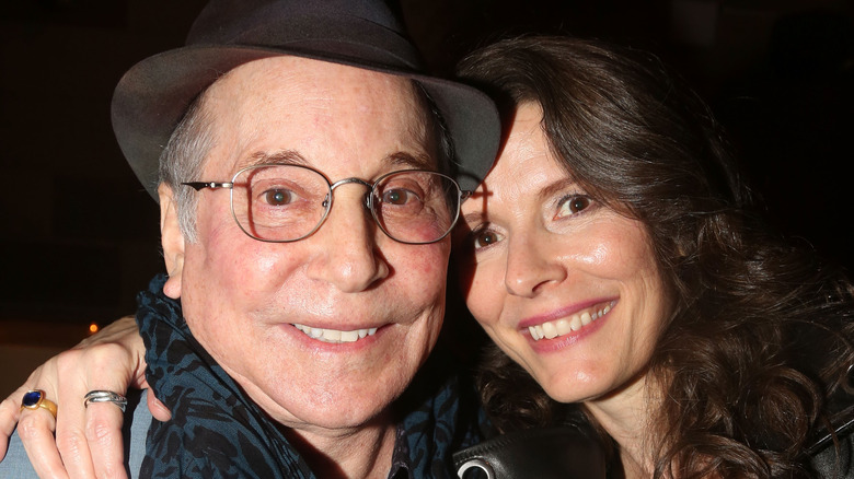 Paul Simon and Edie Brickell embracing and smiling