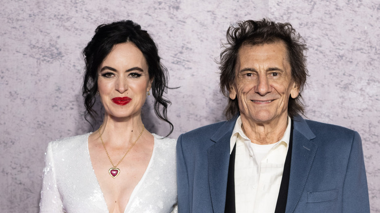 Ronnie Wood and Sally Humphreys smiling and staring ahead