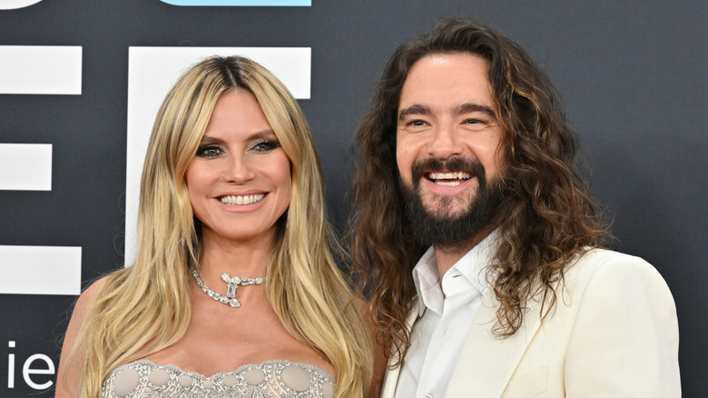 Tom Kaulitz and Heidi Klum smiling on red carpet
