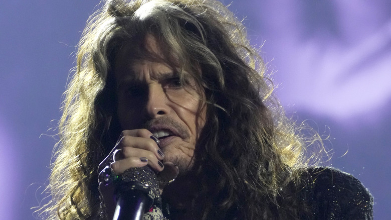 Steven Tyler of Aerosmith singing into a microphone.