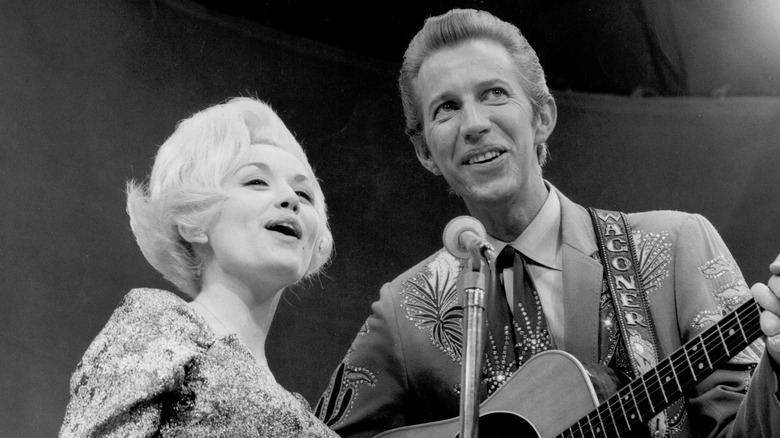 Dolly Parton and Porter Wagoner singing on stage together.
