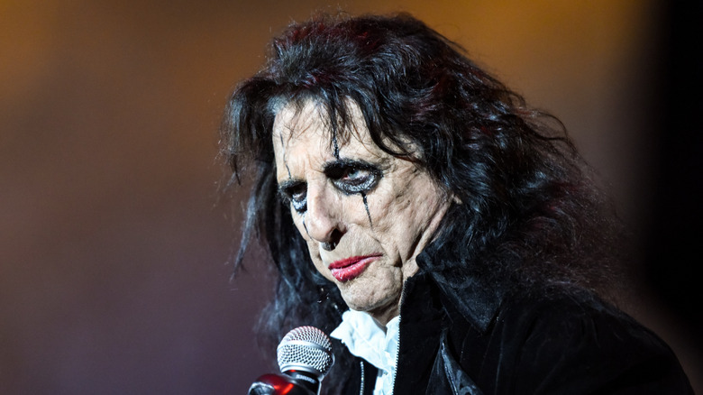 Alice Cooper grimacing while performing onstage