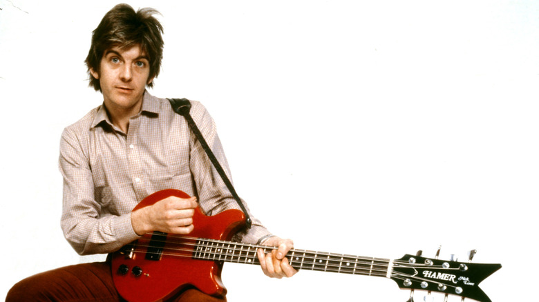 Nick Lowe posing with red guitar