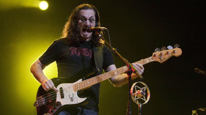 Geddy Lee of Rush on stage playing bass and singing.