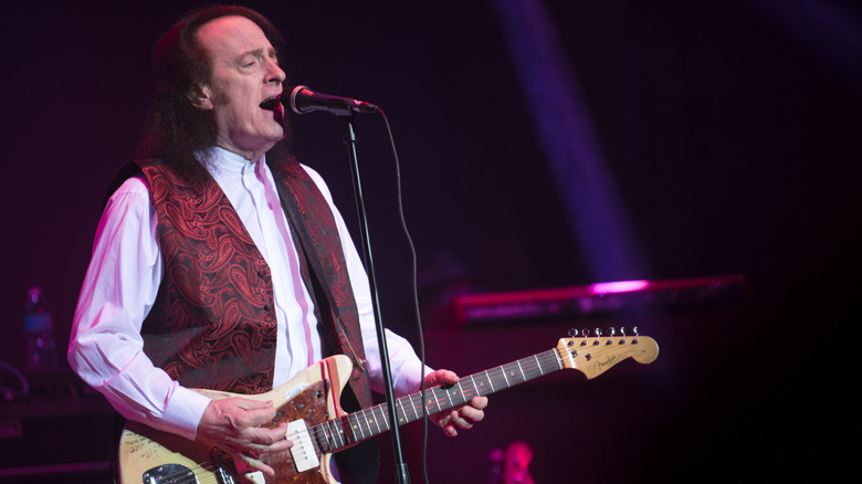 Tommy James onstage playing guitar and singing