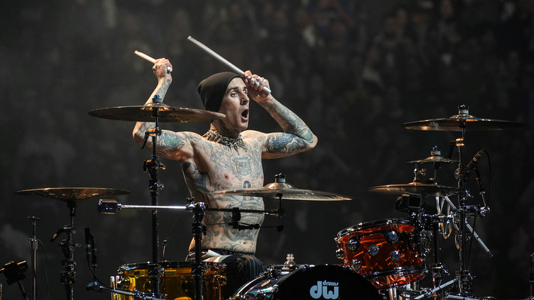 Travis Barker of Blink-182 playing drums with no shirt on