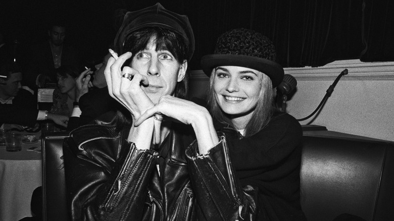Ric Ocasek and Paulina Porizkova sitting together in 1990