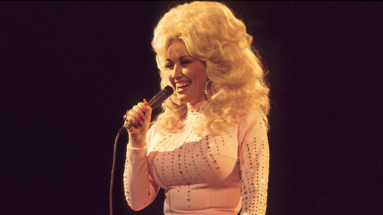 Dolly Parton singing in white dress on stage