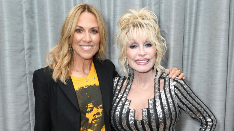 Sheryl Crow and Dolly Parton stood smiling together at event