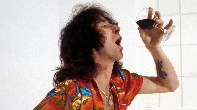 Bon Scott holding glass of wine in publicity shot