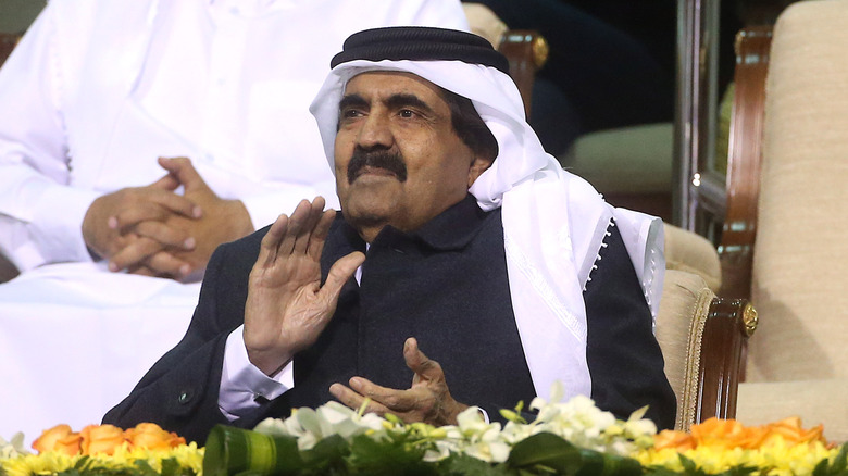 Hamad bin Khalifa Al Thani claps while watching a World Cup match