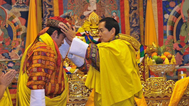 Jigme Singye Wangchuck of Bhutan placing the crown on his son's head