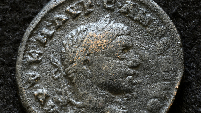 Grey damaged coin of emperor Elagabalus wearing laurels