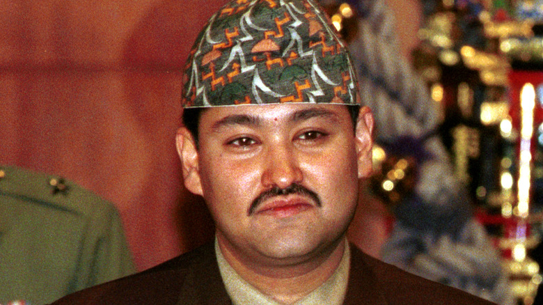 Prine Dipendra in colorful hat and moustache at event