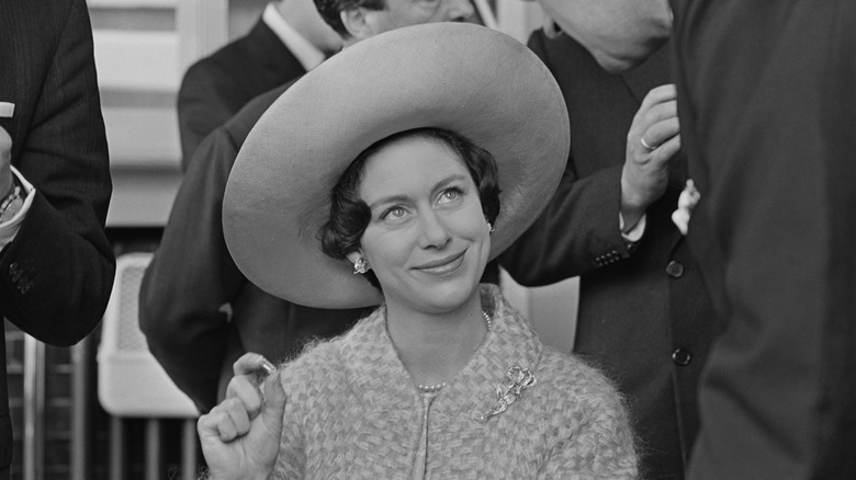 Princess Margaret sat smiling in wide hat at event