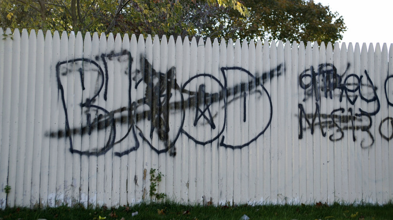 Gang graffiti tags on a fence