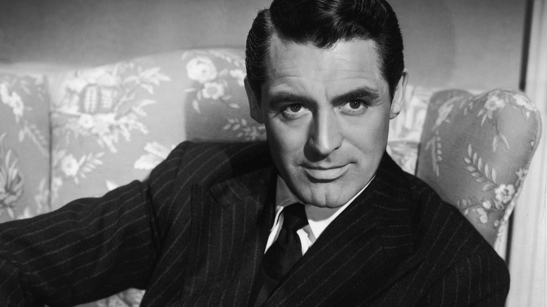 Cary Grant, seated and posing
