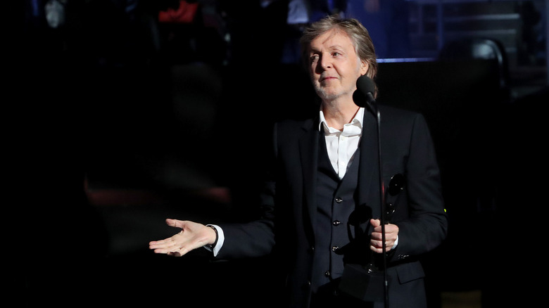 Paul McCartney on stage with microphone