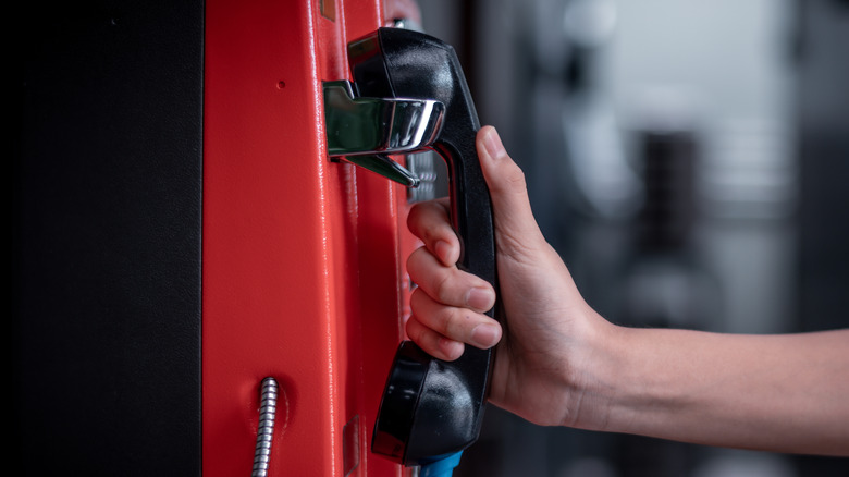 A hand holding a payphone receiver