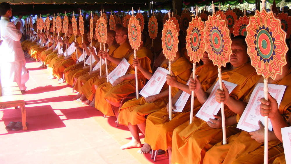 row of monks kneeling and holding large staffs