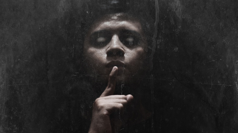 man with finger in front of mouth
