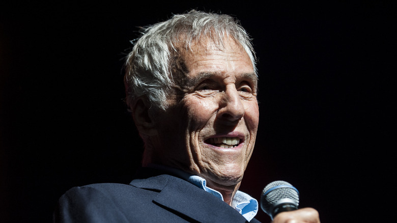 Burt Bacharach holding a microphone on stage