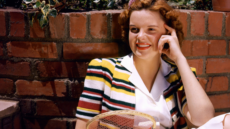Judy Garland smiling with tennis racket