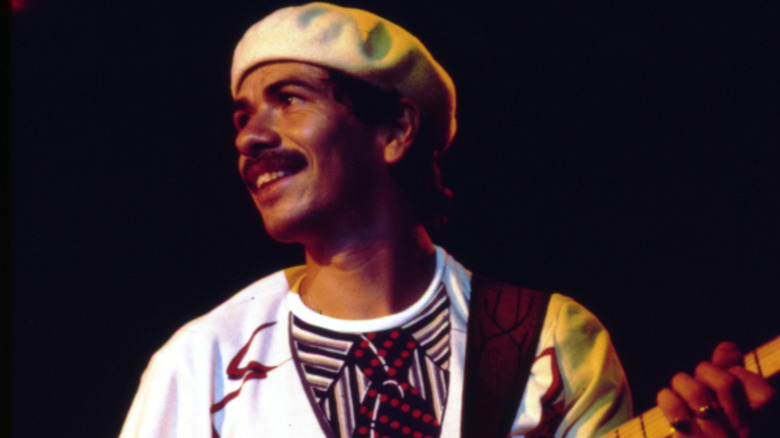 Carlos Santana smiling on stage with his guitar circa 1970
