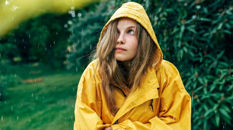 woman looks up at the rain