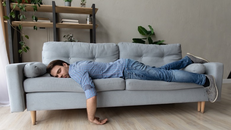 man falls asleep on couch
