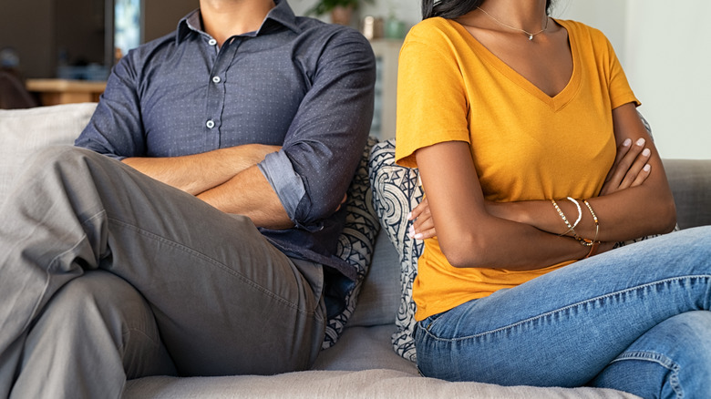 Arguing couple sitting on house