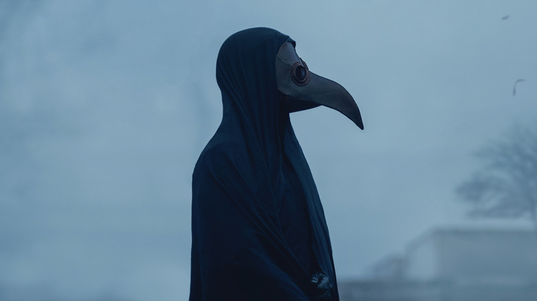 a performer wearing a plague mask