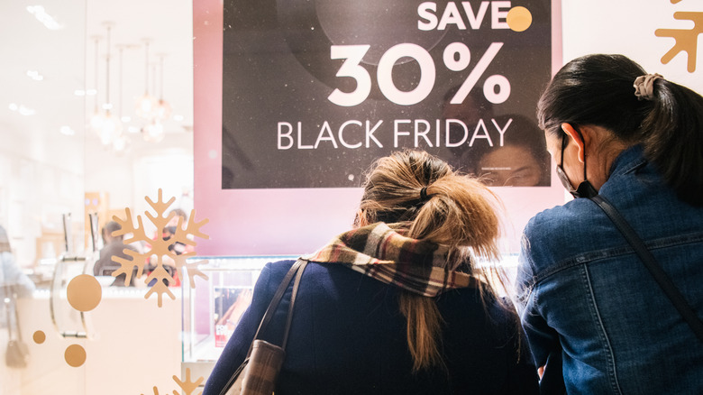 women looking at black friday sign