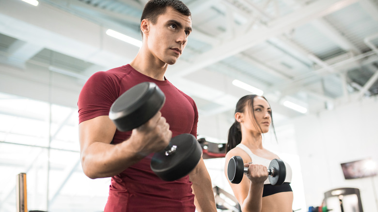 man and woman lifting hand weights