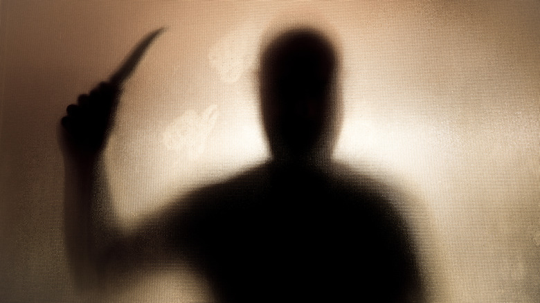 A silhouette of a man wielding a knife