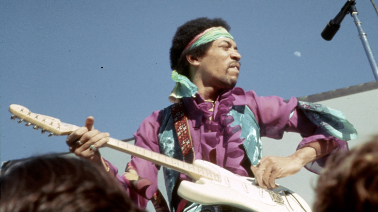 Jimi Hendrix playing guitar at outdoor concert