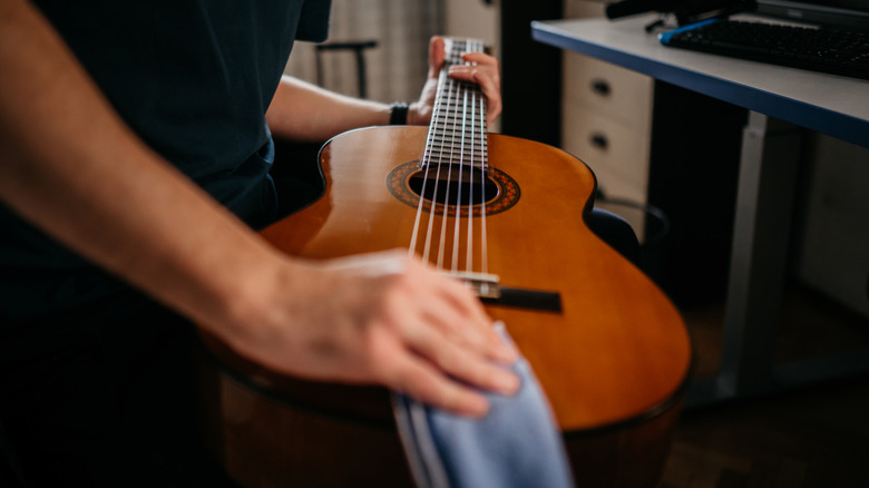 Man wiping down guitar