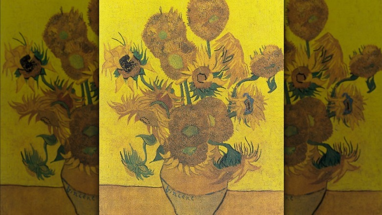 Fourteen sunflowers in a vase yellow background