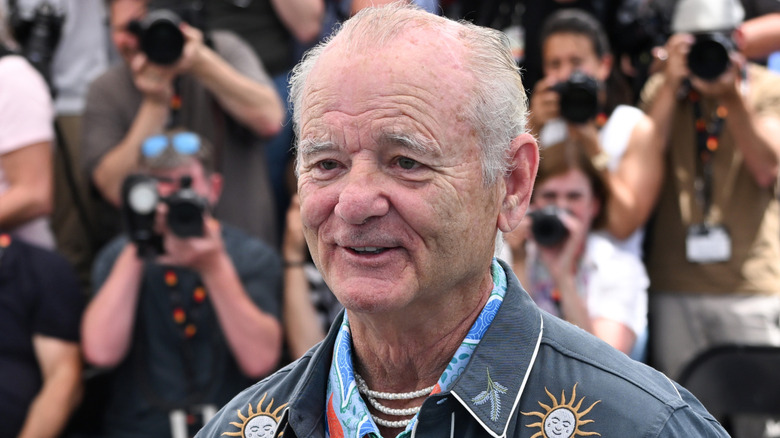 Bill Murray in print jacket in front of photographers