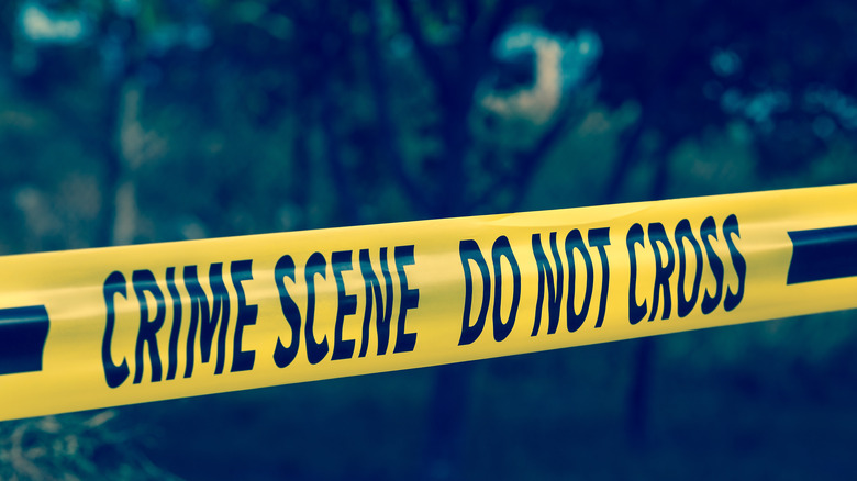 crime scene tape over blurred background