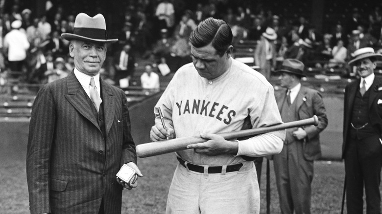 Babe Ruth signing a bat in 1929