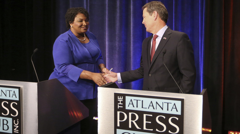 Abrams and Brian Kemp shake hands