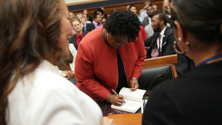 Abrams autographs a book 